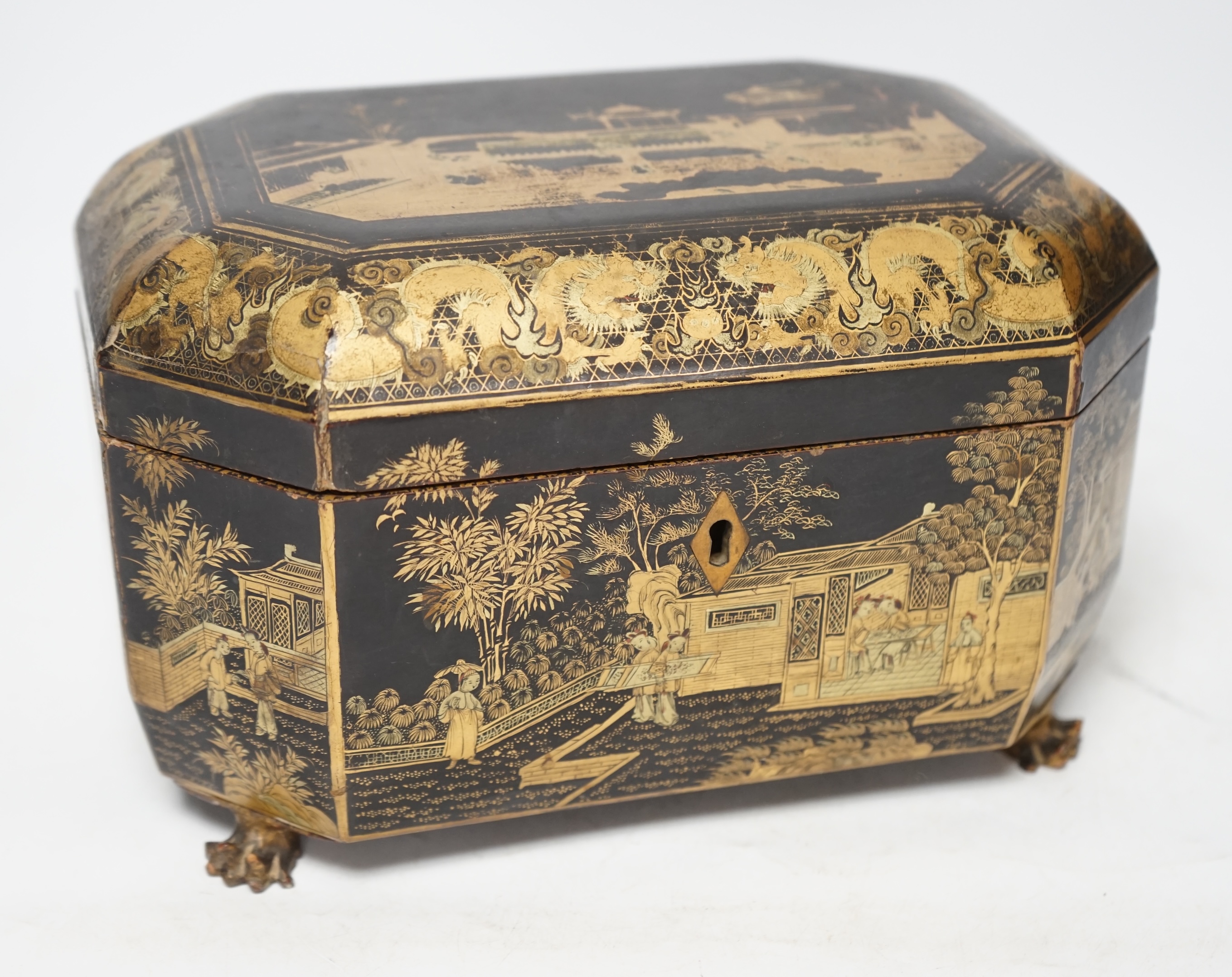 A mid 19th century Chinese export black and gold lacquer tea caddy, retaining engraved pewter tea canisters, raised on paw feet, 26cm wide. Condition - poor
